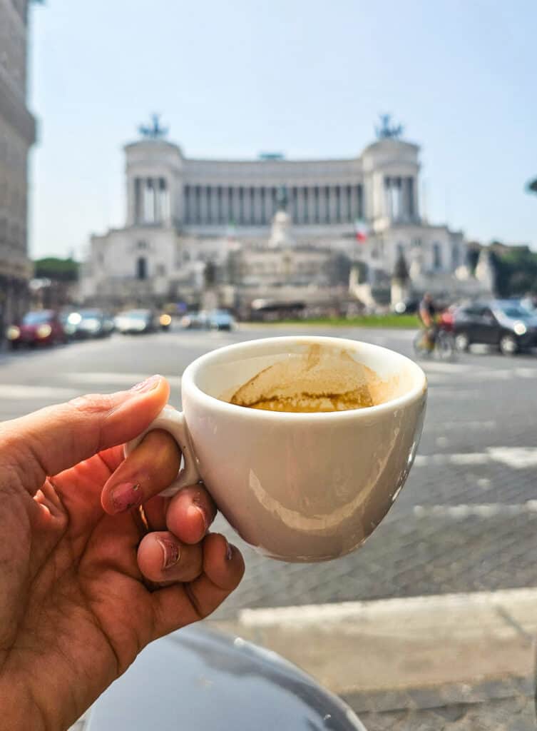 person holding cup up in front of monument view