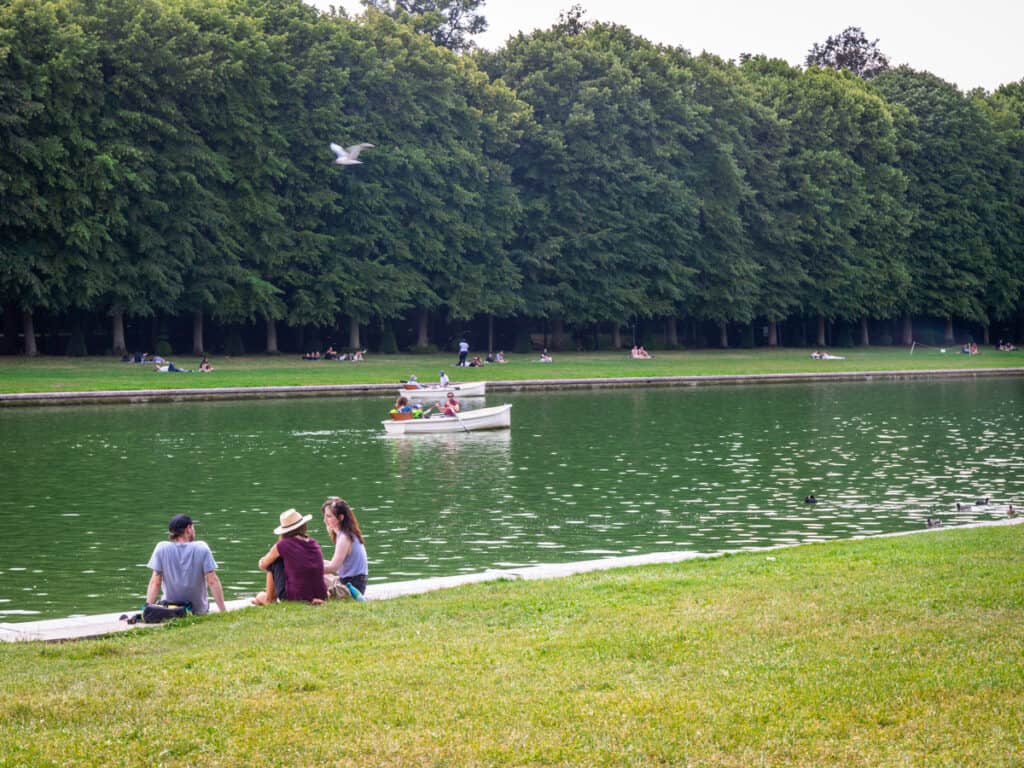 people sitting beside the ground canal