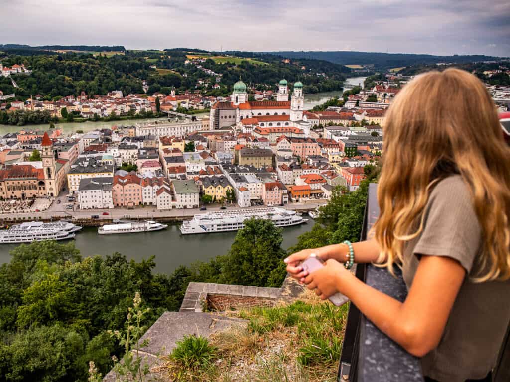 Girl overlooking a city from high on a hill