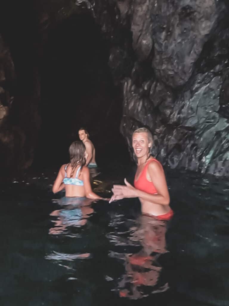 caz smiling at camera in a sea cave