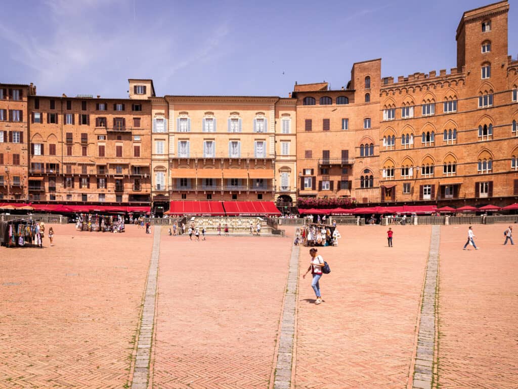 person walking across Piazza del Campo