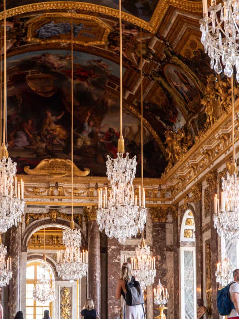 chandeliers hanging from frescoed ceiling.