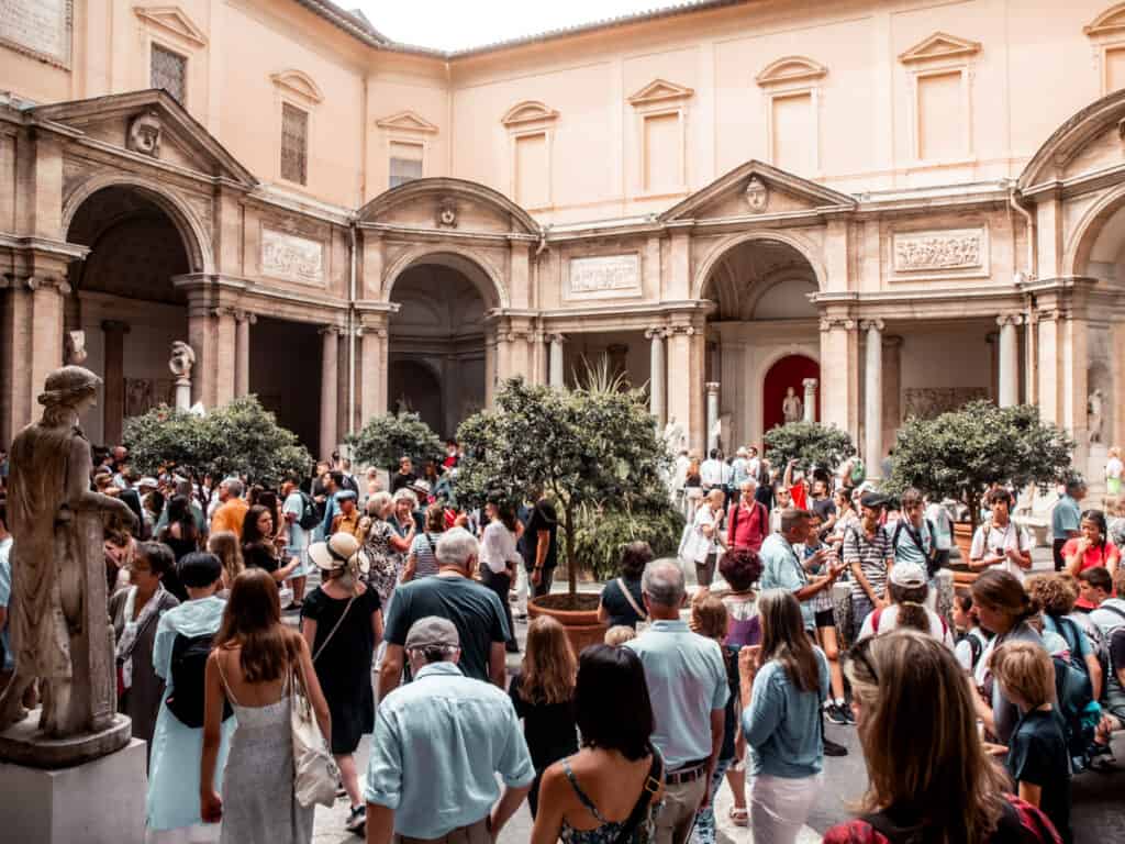 people inside courtyard looking at statutes