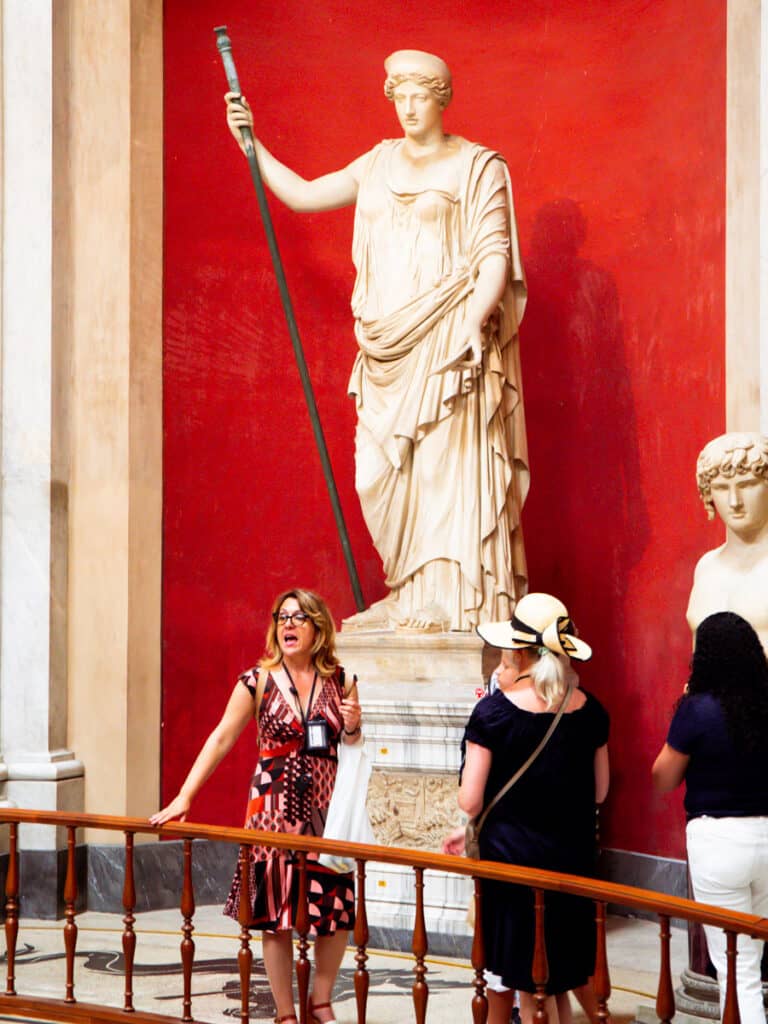 tour group standing under statue inside vatican