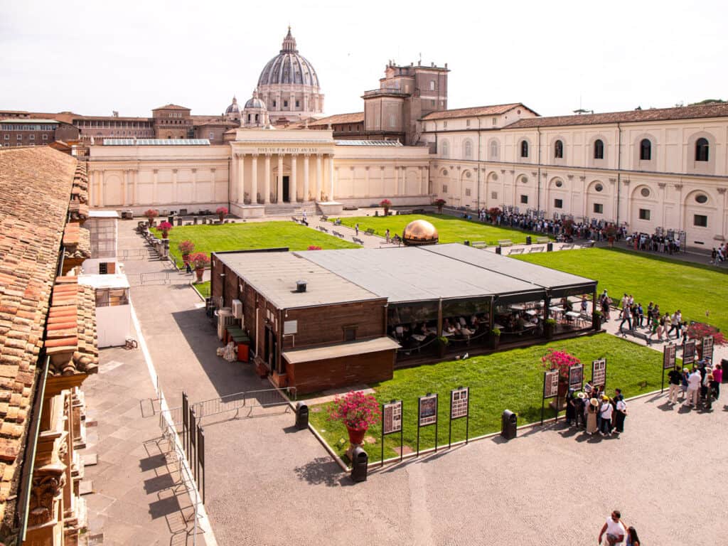 looking over the courtyard in vatican museum with st peter's dome in the background