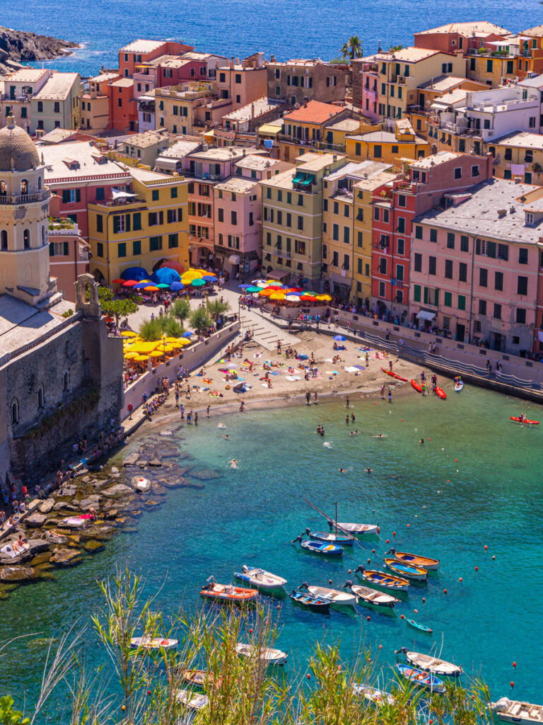 overlooking colorful buildings of vernazza and small harbor beach