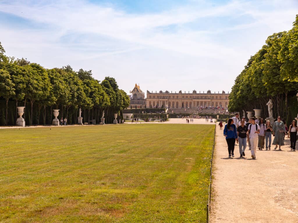 people walking on dirt path in gardens