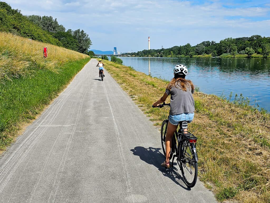 Girls biking next to a river