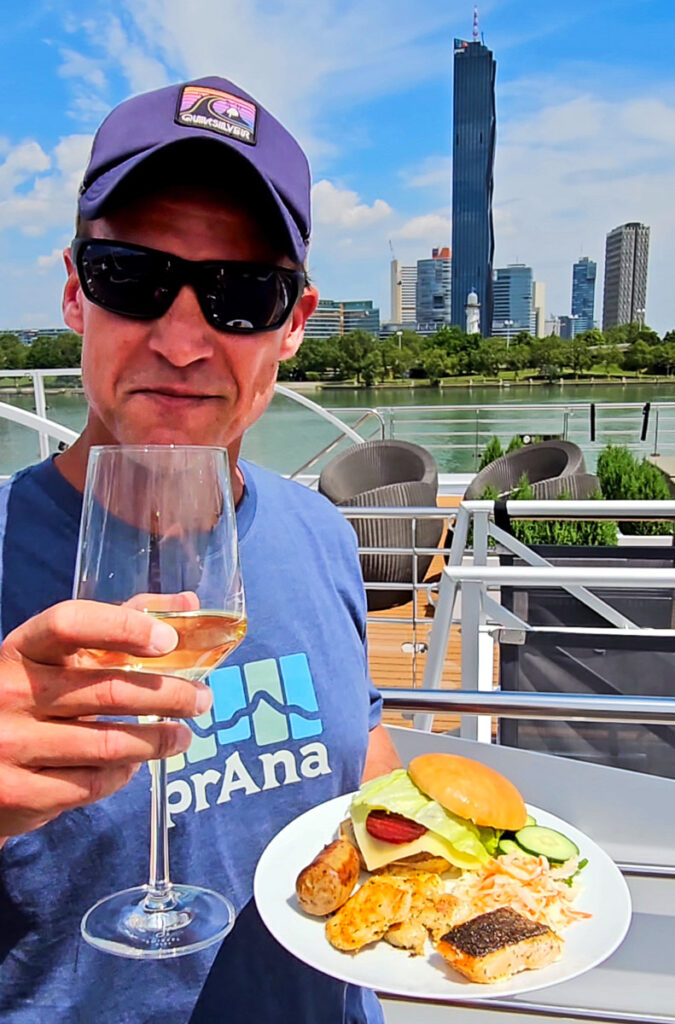 Man drinking a glass of wine and holding a plate of food