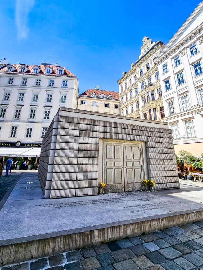 White stone monument in a city surrounded by buildings