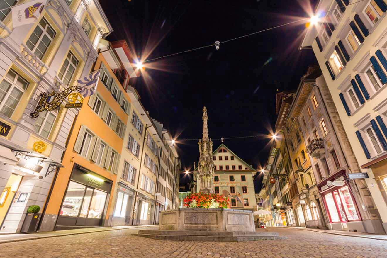 A cobblestone street in a city at night.