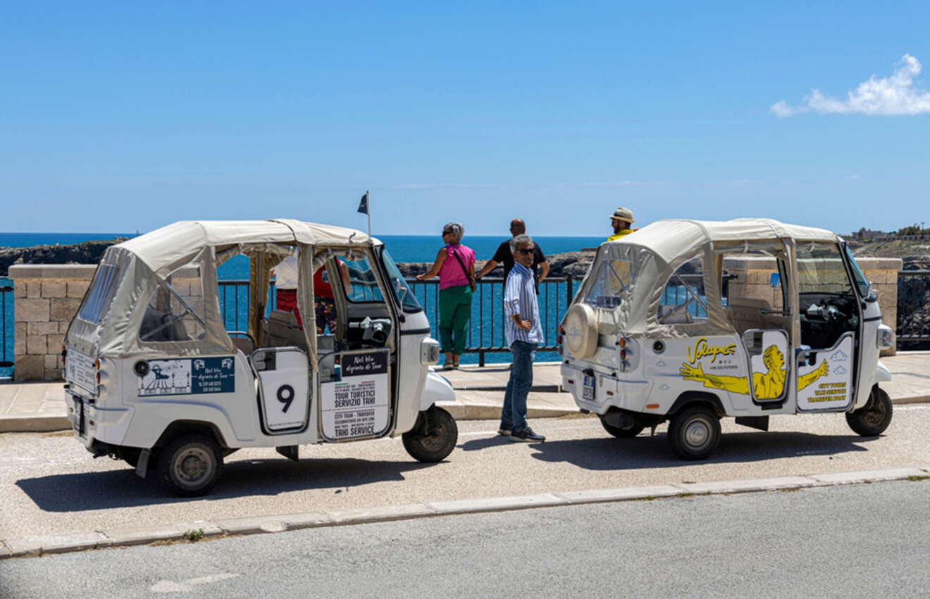 two tuk tuks parked by the road