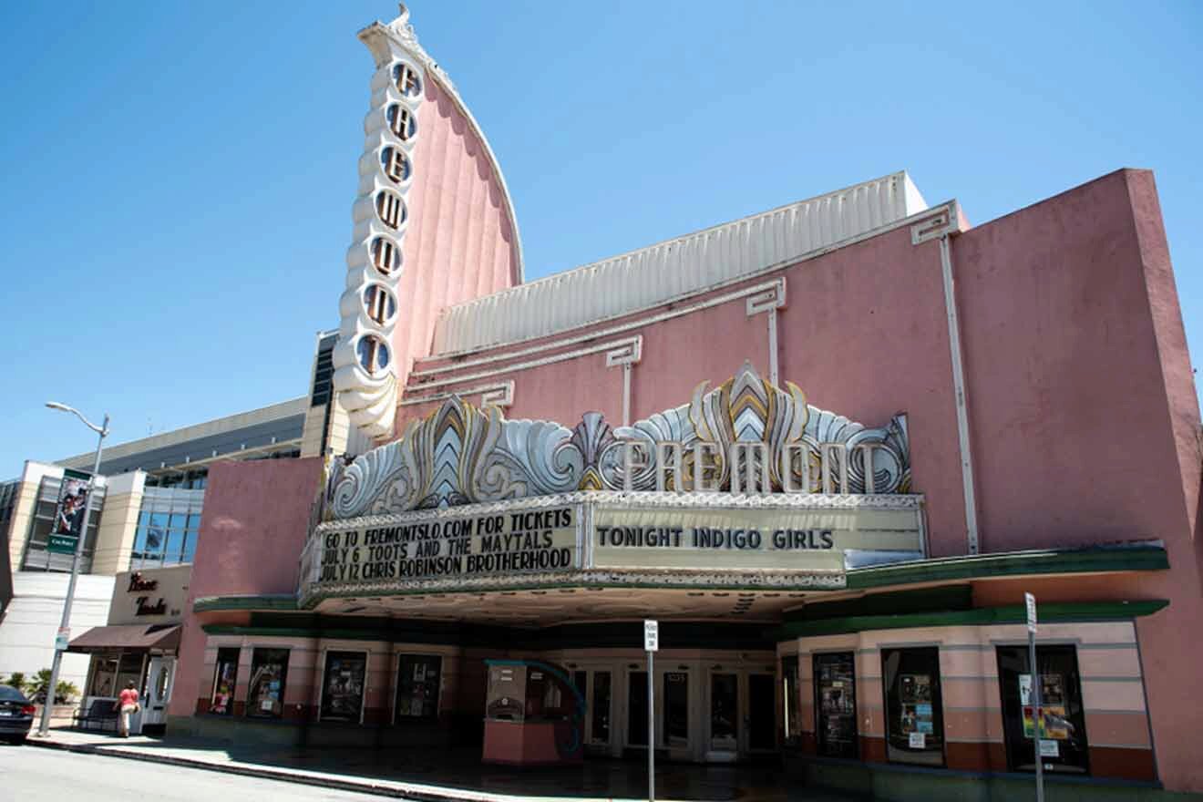 The exterior of a pink theater on a city street.