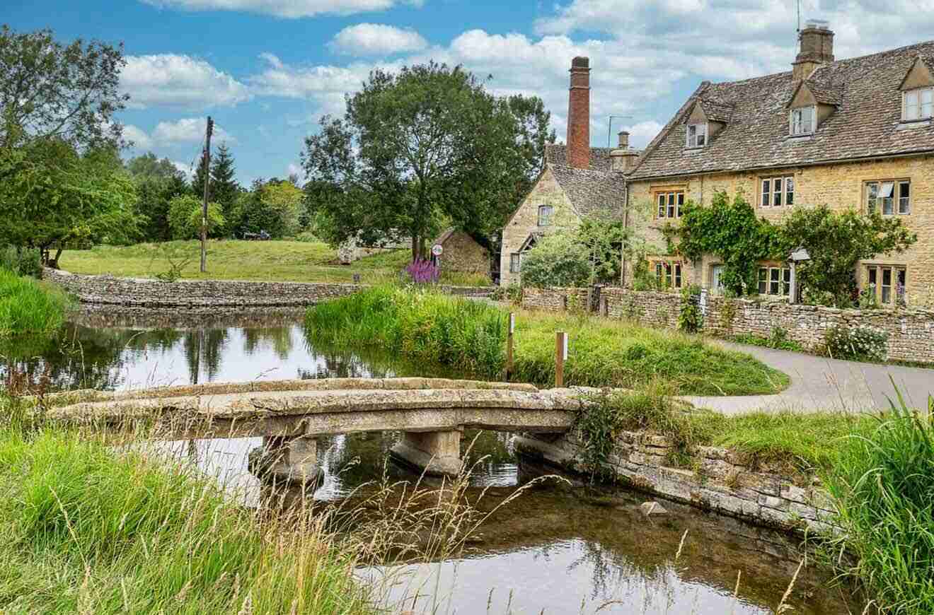 street with houses by a river with a stone bridge in the foreground