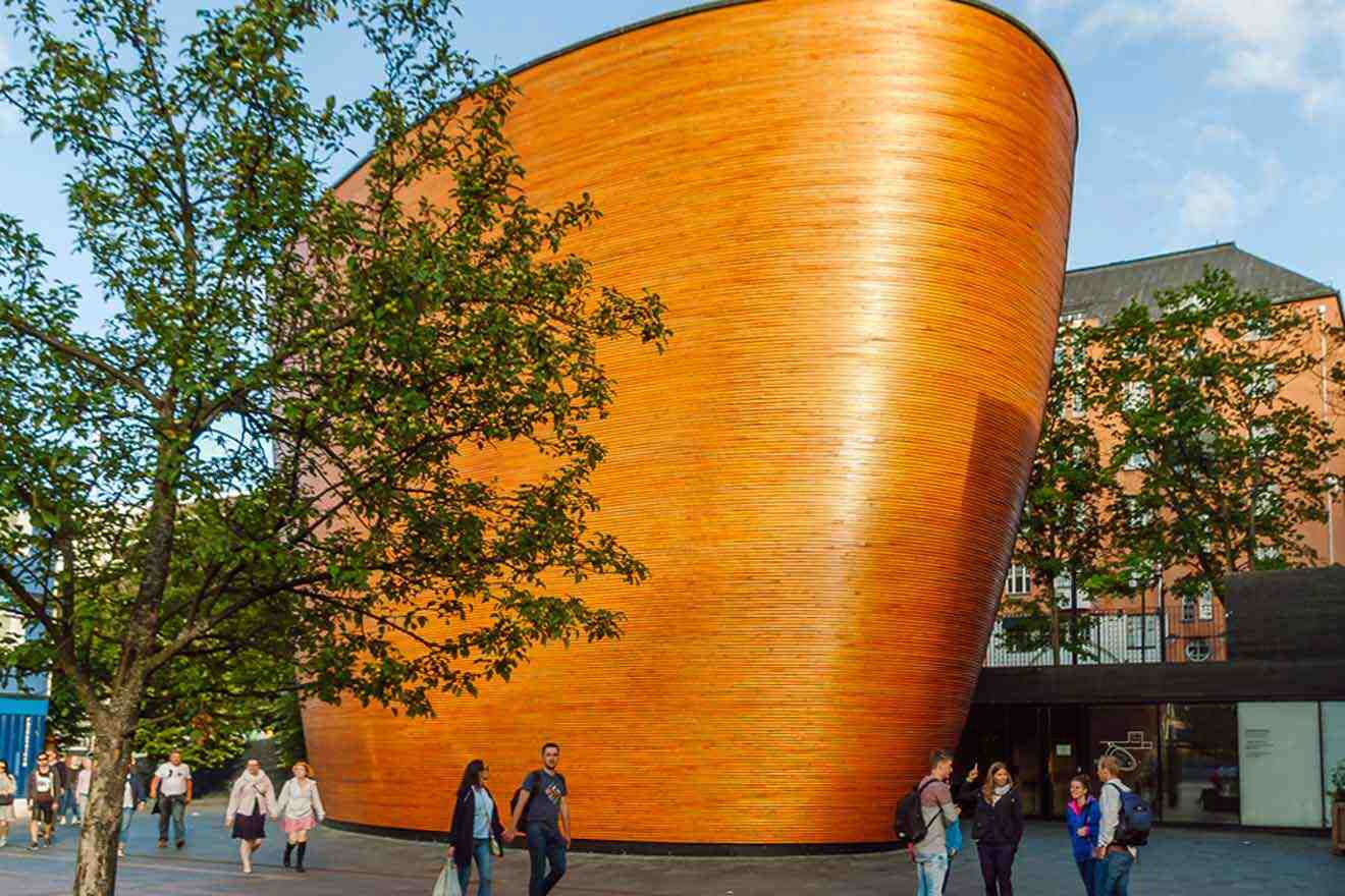 A large wooden building with people walking in front of it.