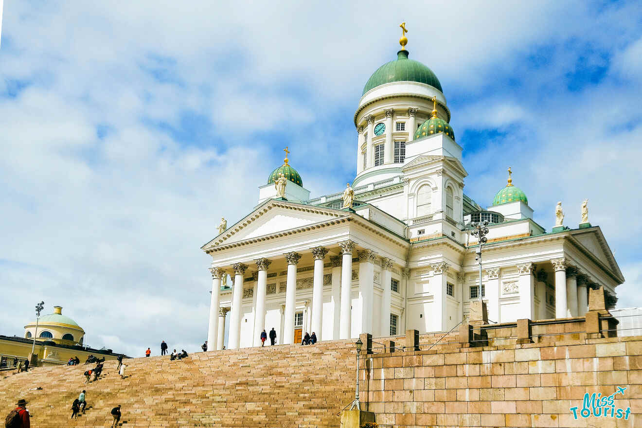 people going up the stairs to a white church