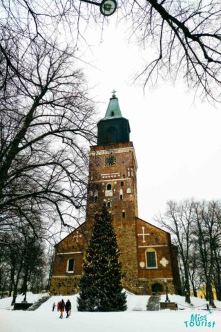 A church with a clock tower in the snow.