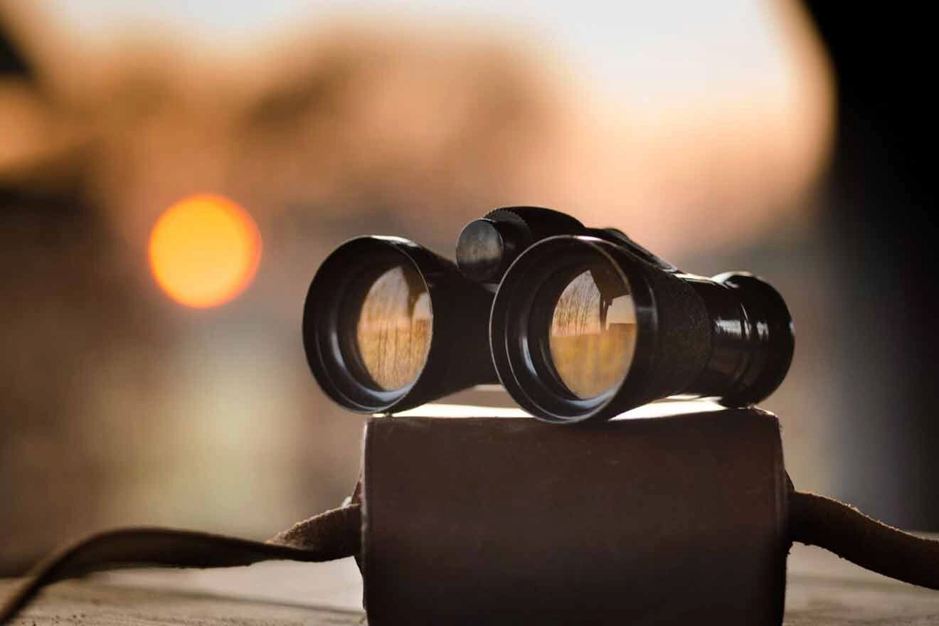 A pair of binoculars sitting on top of a bag