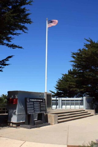 An american flag is flying over a monument.