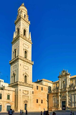 A church with a tower in the middle of a square.