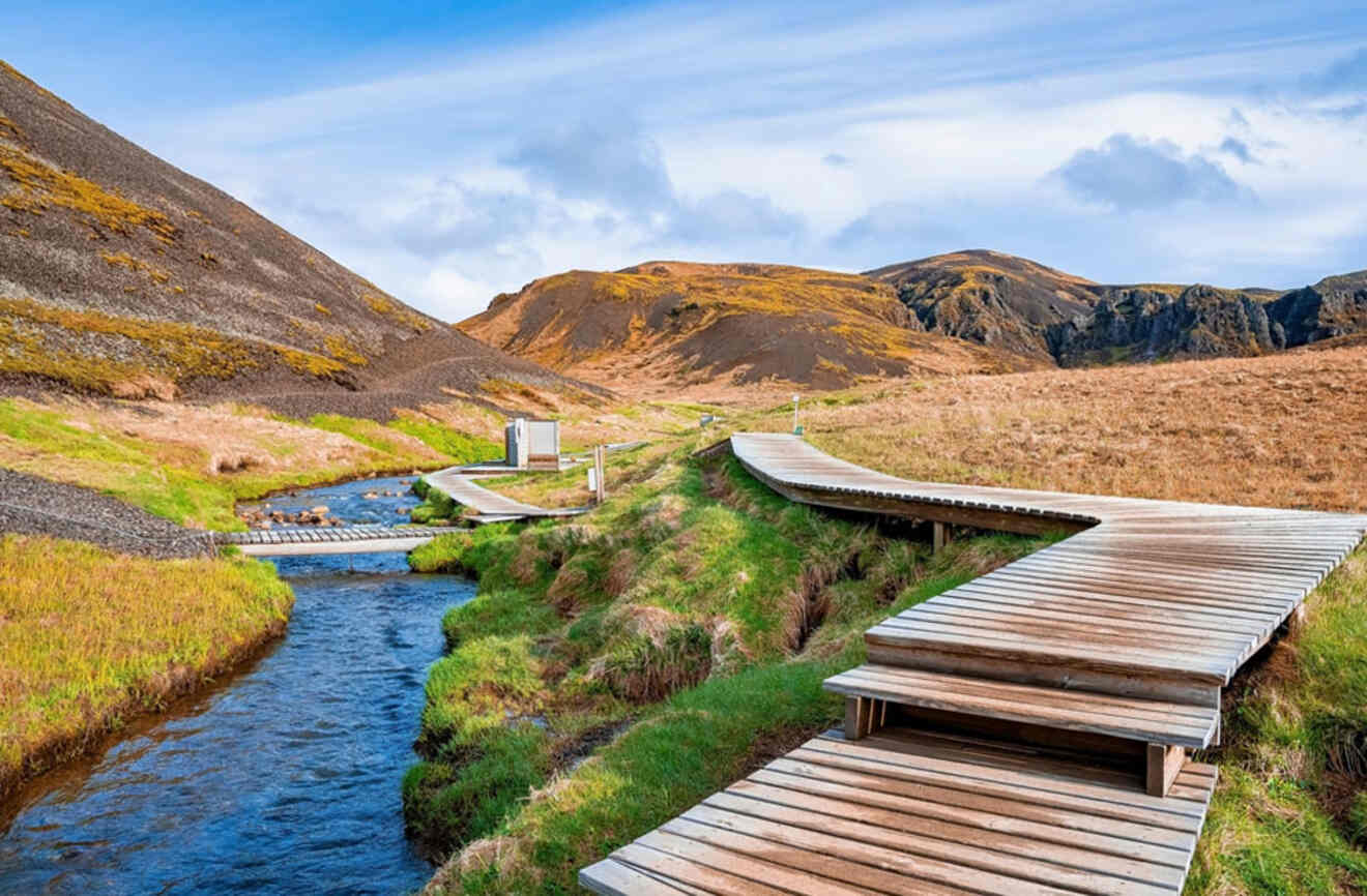 a wooden boardwalk along a hot spring river in the mountains