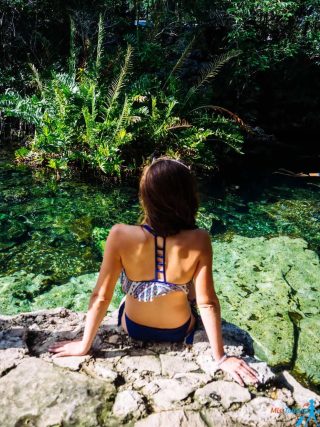 woman sitting on a rock in a cenote