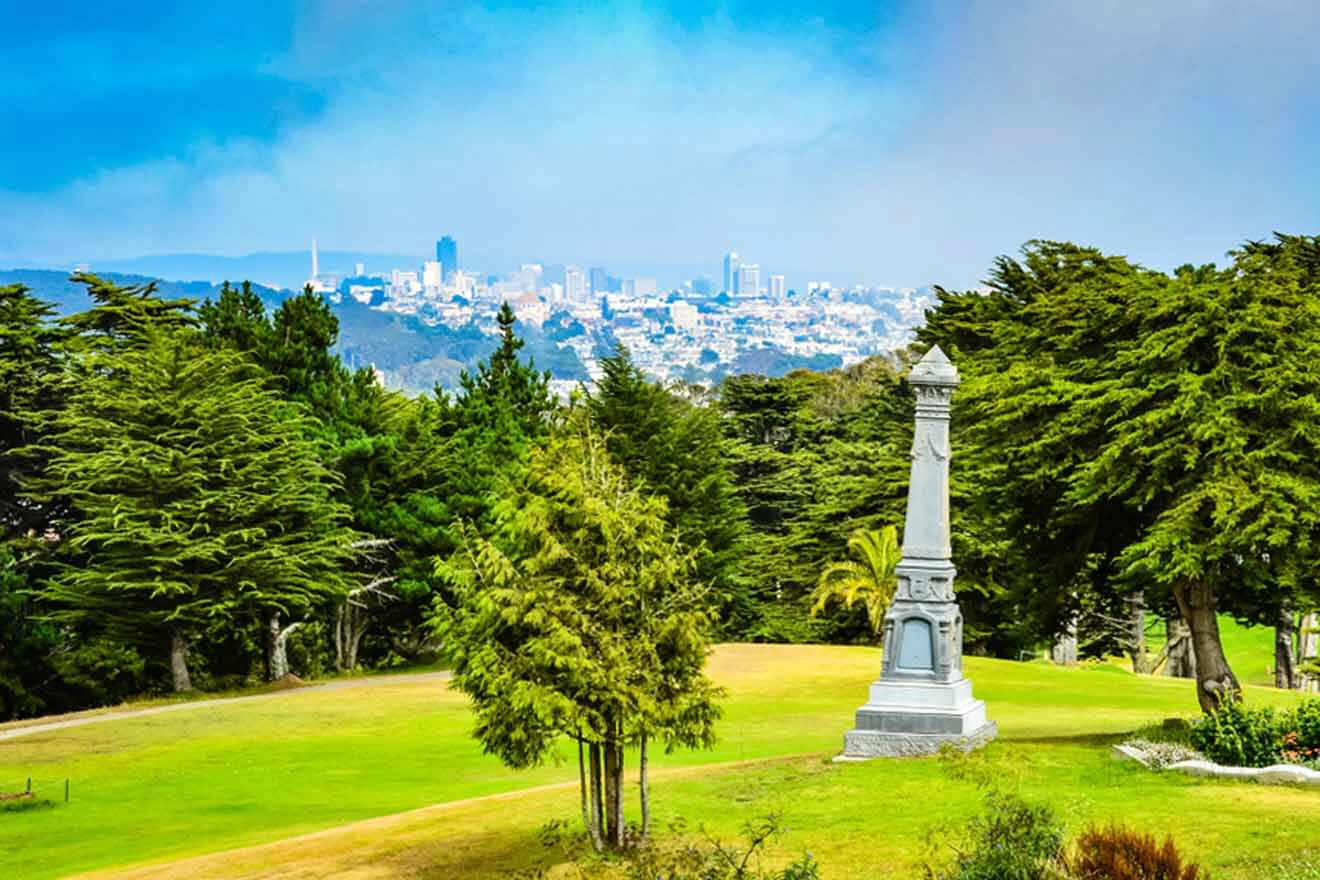 sculpture in a park with the city in the background