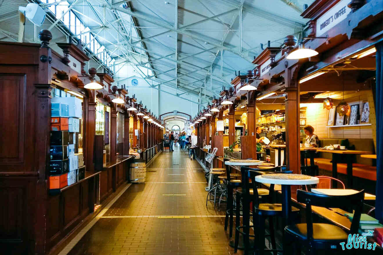 A long line of wooden tables and chairs in a market.