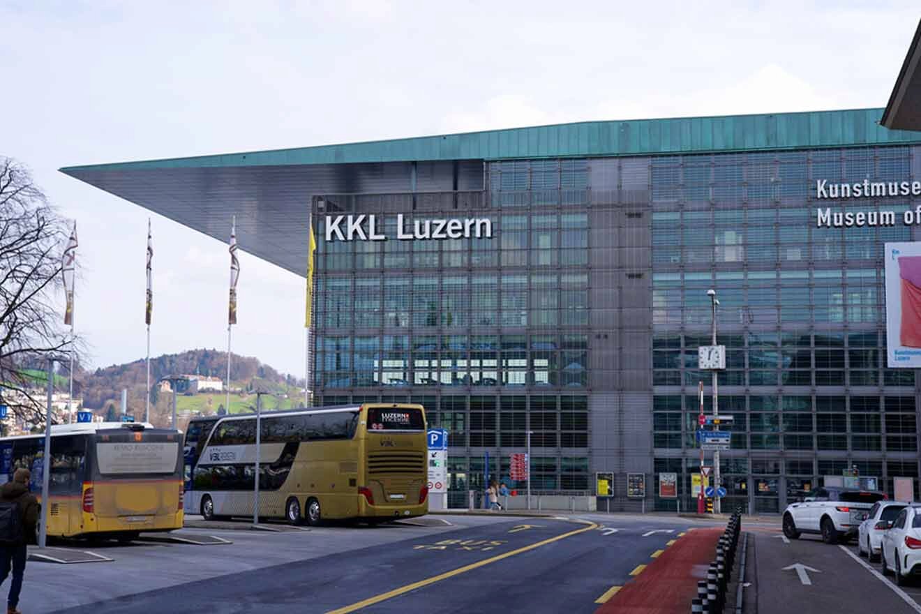 Buses parked in front of a large building.