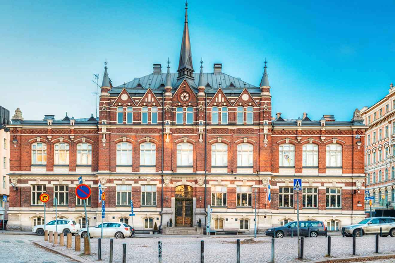 A large red brick building with parked cars in front of it