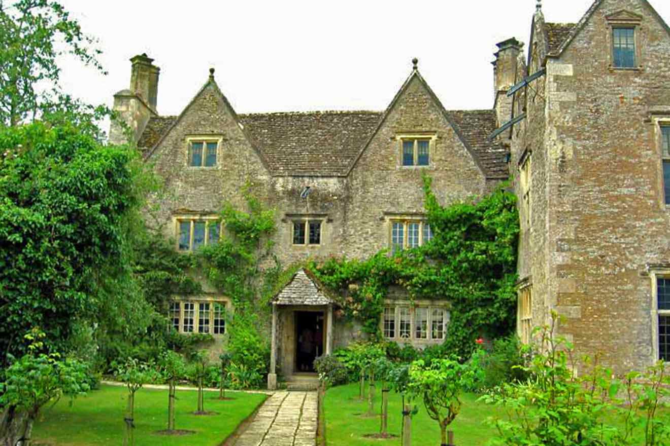 A large stone house with a green lawn and trees.