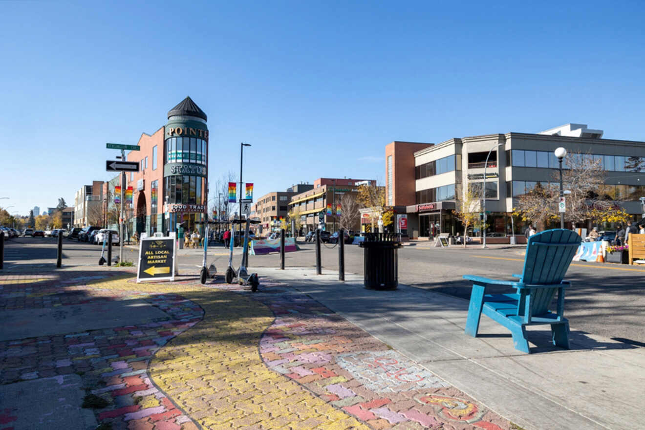 A blue chair sits on a sidewalk in a city.