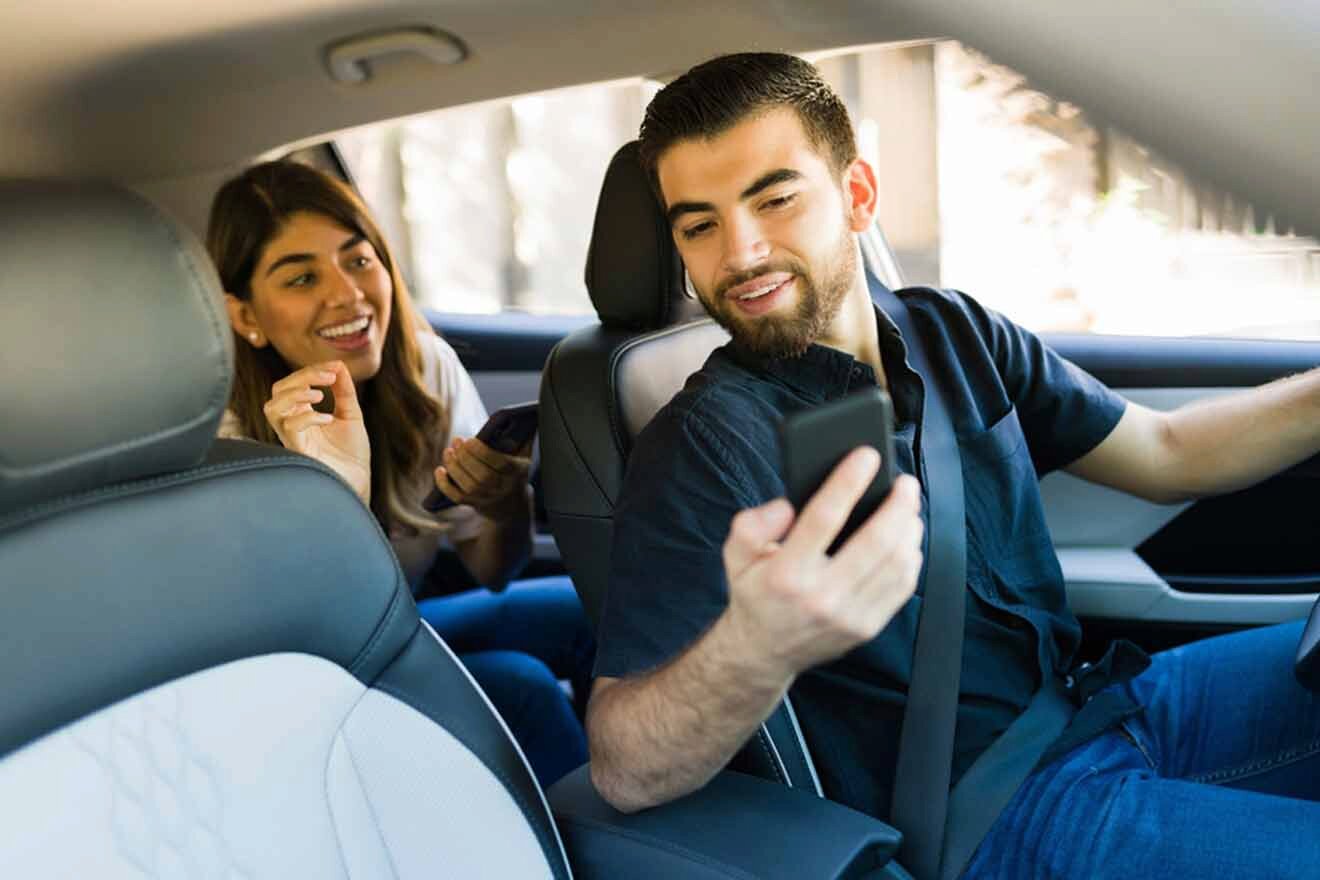 A man and woman are sitting in the back seat of a car.