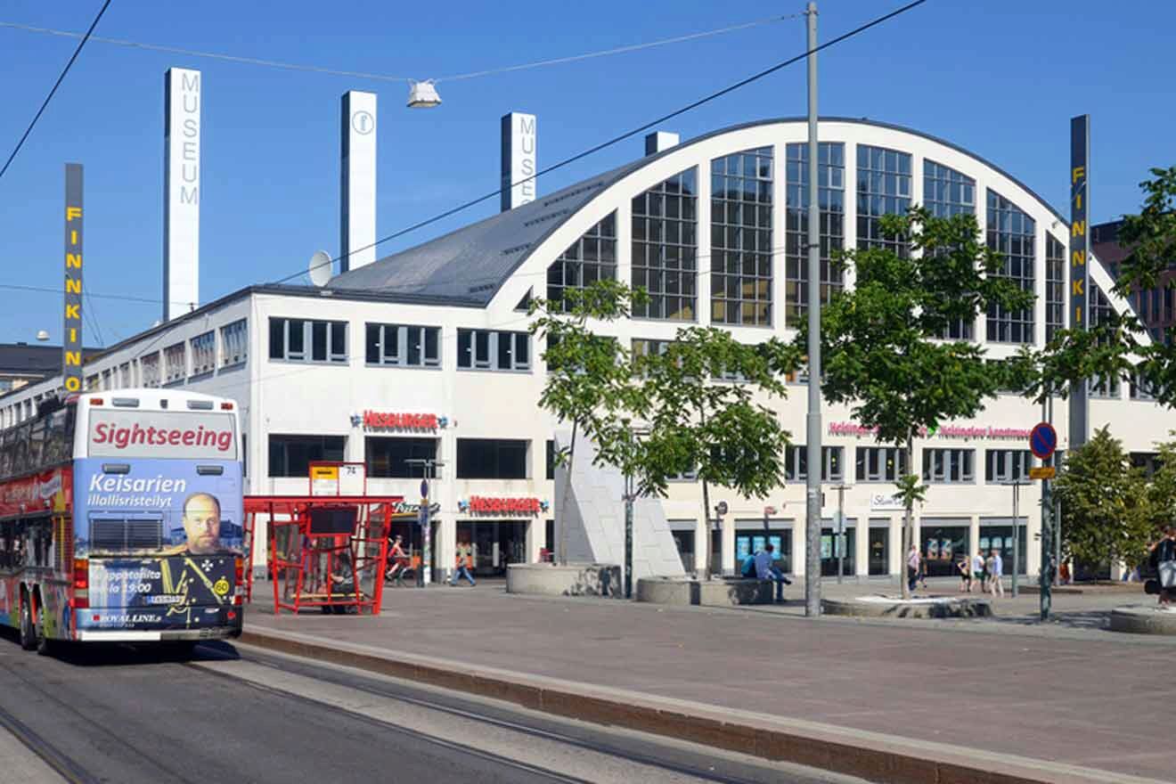 A bus on the road next of large building.