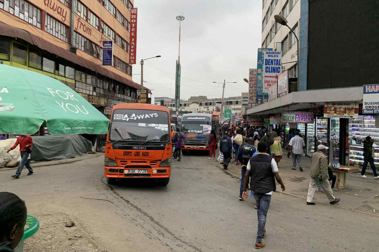 people and buses on a crowded street in the city