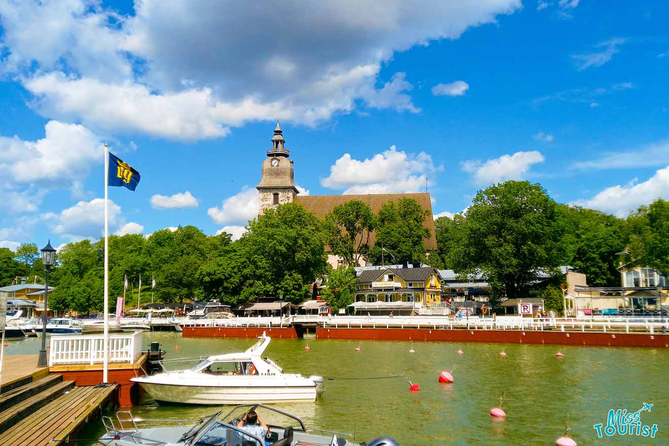 A boat docked at a dock with a church in the background.