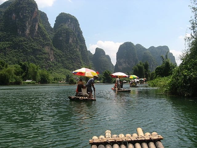 people bamboo rafting down river