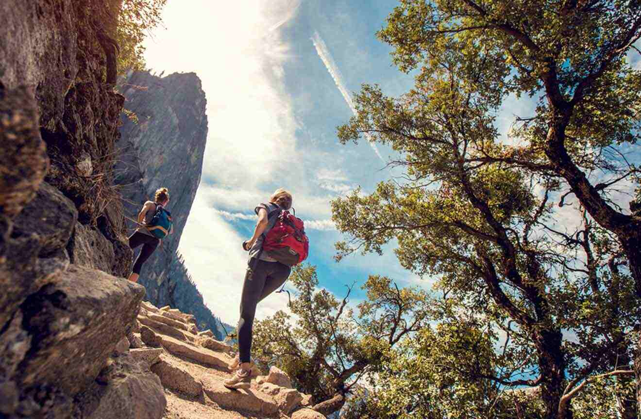 Two people hiking up a rocky path.