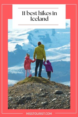 a man holding hands with two kids standing on top of a peak looking at mountains below