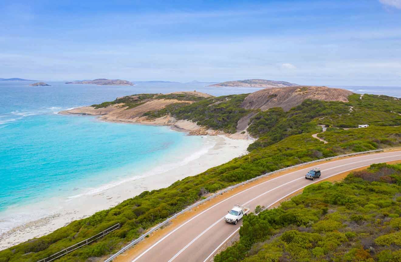 A car driving down a road near a beach and ocean.