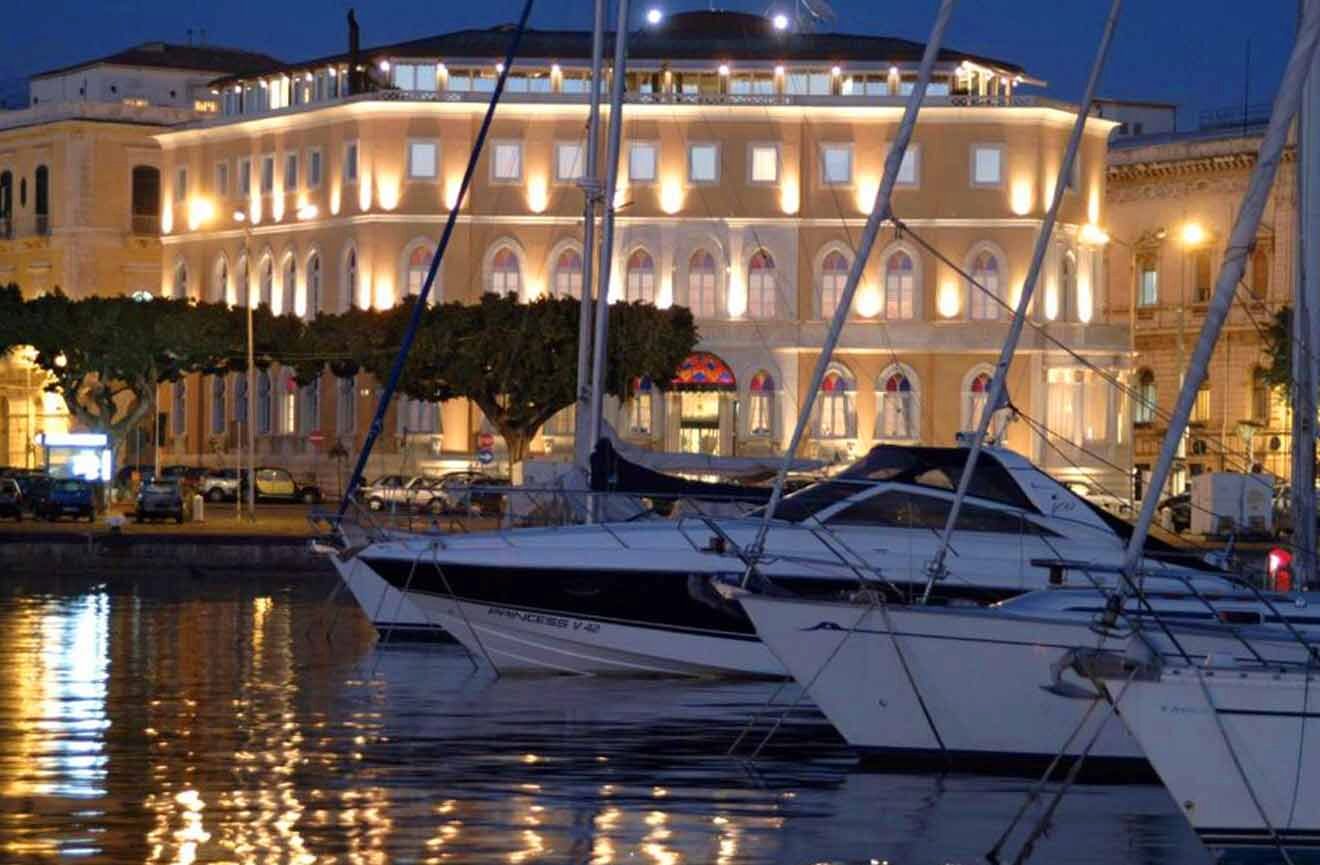 docked boats with a building where the hotel is located in the background