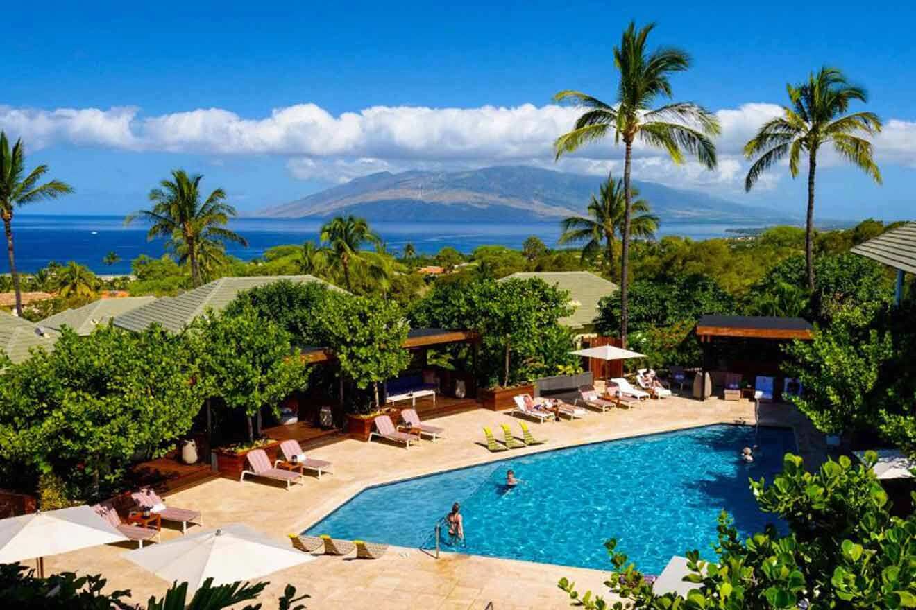 A swimming pool surrounded by palm trees and a view of the ocean.