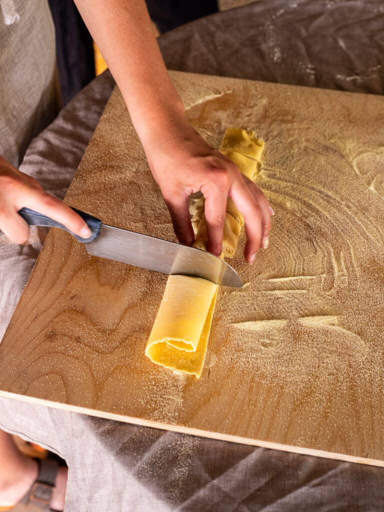 person cutting pasta