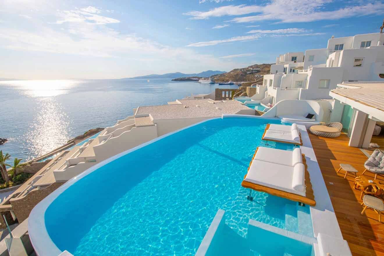 A swimming pool with lounge chairs and a view of the ocean.