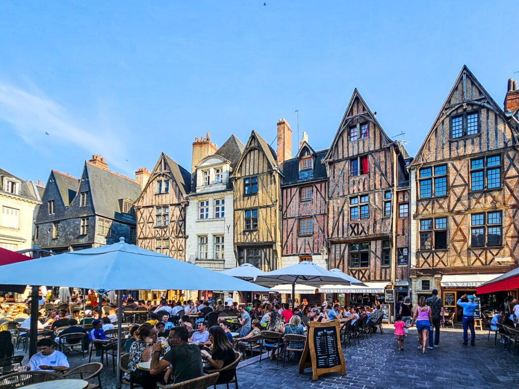 medieval style buildings surrounding Place Plumereau with people eating in the square