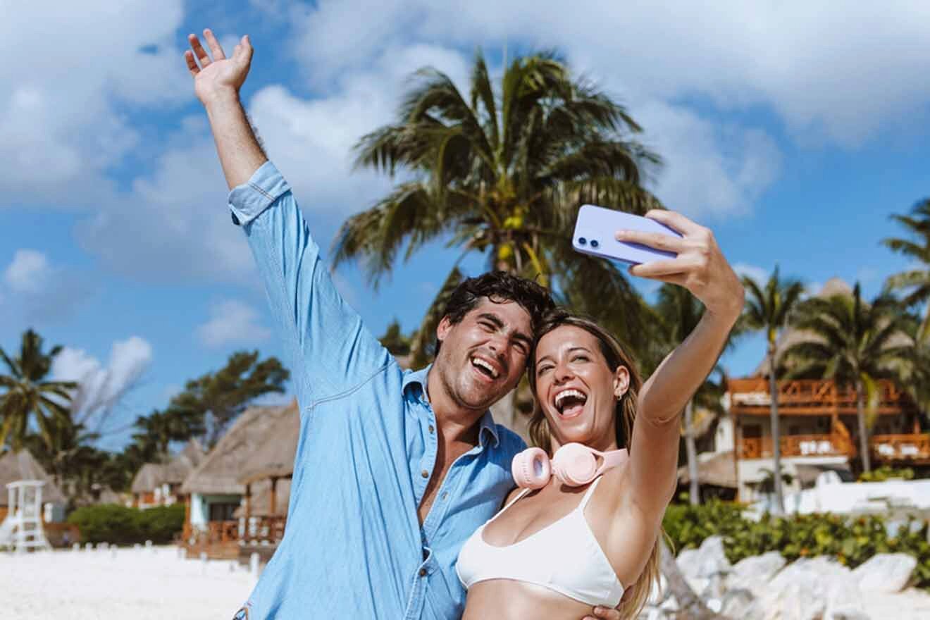 A man and woman taking a selfie on the beach.