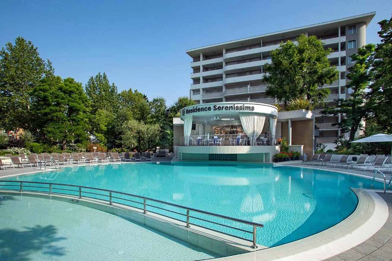 swimming pool of a hotel with the hotel's building in the background