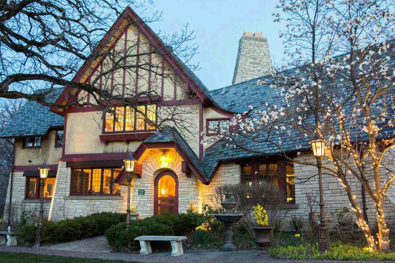 A tudor style house lit up at dusk.