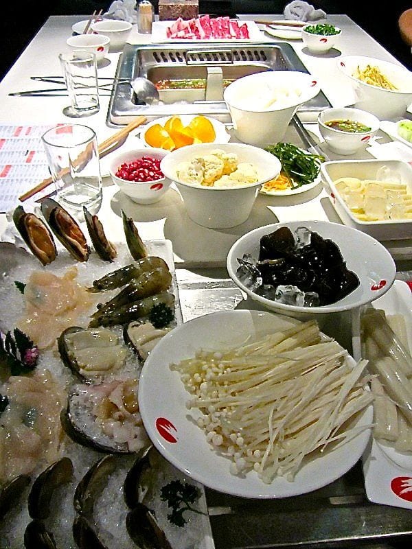 table full of ingredients for chinese hot pot