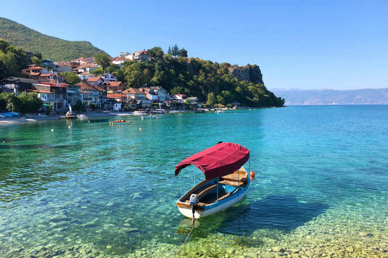 A boat docked in the water near a village.